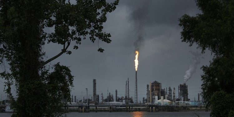 NORCO, LA - AUGUST 21: A gas flare from the Shell Chemical LP petroleum refinery illuminates the sky on August 21, 2019 in Norco, Louisiana. Located about 10 miles up the Mississippi River from New Orleans, the plant agreed to install $10 million in pollution monitoring and control equipment in 2018 to settle allegations that flares used to burn off emissions were operating in violation of federal law (the Clean Air Act). Many of the coastal parishes in Louisiana have a long and ongoing history in oil and gas production, which is often at odds with concerns of environmentalists. (Photo by Drew Angerer/Getty Images)