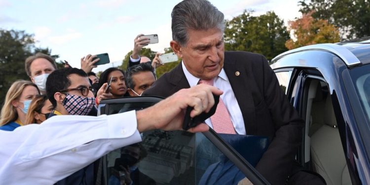 US Senator Joe Manchin (D-WV) gets into a car as members of the press ask question, after he left the US Capitol in Washington, DC, on October 28, 2021. - US President Joe Biden announced a &quot;historic&quot; framework Thursday for spending $3 trillion on America's social safety net and crumbling infrastructure, but his claim to be on the cusp of a major political victory had yet to get full backing from Democrats. Two conservative Democratic senators who have held up the social spending component, calling it too expensive, Joe Manchin and Kyrsten Sinema, sounded positive but did not commit to supporting Biden's framework. (Photo by MANDEL NGAN / AFP) (Photo by MANDEL NGAN/AFP via Getty Images)