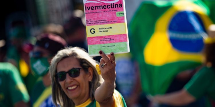 BRASILIA, BRAZIL - MAY 15: A supporter of President of Brazil Jair Bolsonaro holds a large box of box of Ivermectin, used by many people treat COVID-19, during a protest organized to show support to his government at Esplanada dos MinistÃ©rios on May 15, 2021 in Brasilia, Brazil. Bolsonaro currently faces a parliamentary investigation over Coronavirus pandemic response. (Photo by Andressa Anholete/Getty Images)