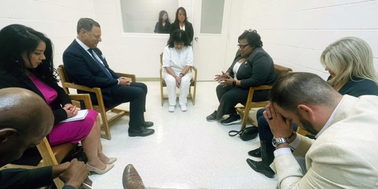 In this April 6, 2022 photo provided by Texas state Rep. Jeff Leach, Texas death row inmate Melissa Lucio, dressed in white, leads a group of seven Texas lawmakers in prayer in a room at the Mountain View Unit in Gatesville, Texas. The lawmakers visited Lucio to update her about their efforts to stop her April 27 execution. The lawmakers say they are troubled by Lucioâ€™s case and believe her execution should be stopped as there are legitimate questions about whether she is guilty. (Texas state Rep. Jeff Leach via AP)