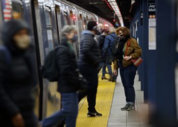 NEW YORK, NEW YORK - NOVEMBER 18: People walk off of a subway train at a Brooklyn station on November 18, 2020 in New York City. In a bid to save $1.2 billion, the Metropolitan Transportation Authority (MTA) announced its budget for the upcoming year which includes cutting as much as 40% of service on subways and buses, and 50% on commuter rail lines. The MTA, which runs the largest public transit service in the nation,  says the cuts are necessary because they have so far been denied $12 billion in federal funds. (Photo by Spencer Platt/Getty Images)