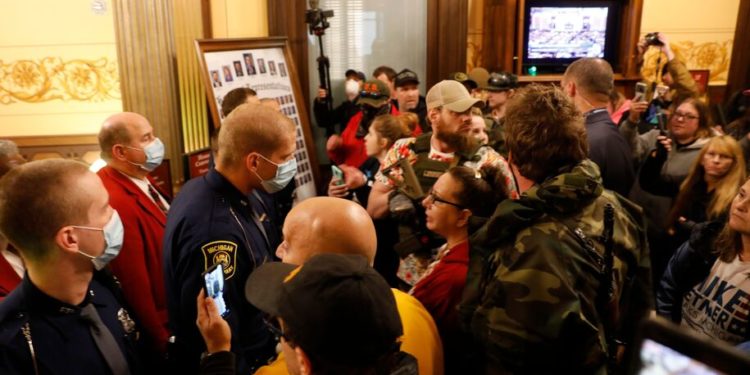 Protestors try to enter the Michigan House of Representative chamber and are being kept out by the Michigan State Police after the American Patriot Rally organized by Michigan United for Liberty protest for the reopening of businesses on the steps of the Michigan State Capitol in Lansing, Michigan on April 30, 2020. - The group is upset with Michigan Gov. Gretchen Whitmer's mandatory closure to curtail Covid-19. (Photo by JEFF KOWALSKY / AFP) (Photo by JEFF KOWALSKY/AFP via Getty Images)