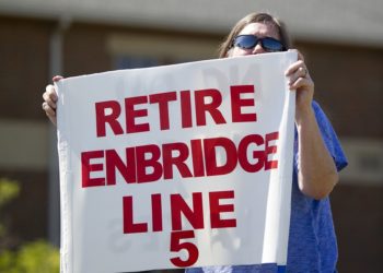 FILE - In this July 6, 2017, file photo, Lauren Sargent, takes part in a protest before the Enbridge Line 5 pipeline public information session in Holt, Mich. The U.S. and Canada will discuss the future of Enbridge Energy's Line 5, a key segment of a pipeline network that crosses part of the Great Lakes and is the subject of rising tension over whether it should be shut down, the White House said Monday, Nov. 8, 2021. (Cory Morse/The Grand Rapids Press via AP, File)