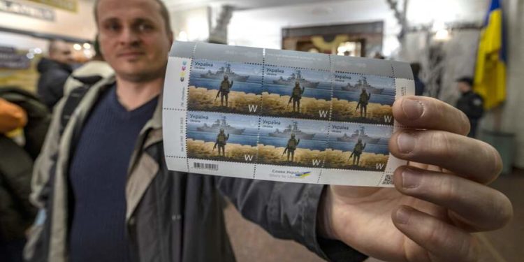 A local resident shows new Ukrainian stamps titled "Russian warship, Go...!" at a post office in the center of Kyiv on April 15, 2022. (Photo by FADEL SENNA / AFP) (Photo by FADEL SENNA/AFP via Getty Images)