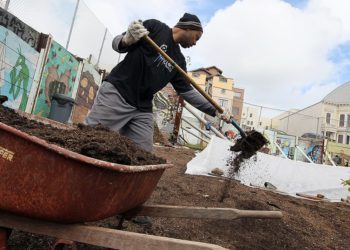 SAN FRANCISCO - MARCH 31:  A volunteer distributes mulch at the "Free Farm" March 31, 2010 in San Francisco, California. A group of garden activists have constructed a community garden on a piece of land that has been vacant since the St. Paulus Church burned down in 1995. The all-volunteer garden will give away all the food that is grown at the garden to local residents and anyone who is in need.  (Photo by Justin Sullivan/Getty Images)
