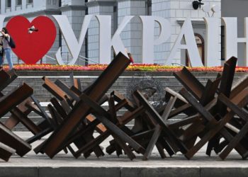 A woman takes a selfie with her son in front of letters forming "I love Ukraine" in the center of Kyiv on June 1, 2022 amid the Russian invasion of Ukraine. (Photo by Sergei SUPINSKY / AFP) (Photo by SERGEI SUPINSKY/AFP via Getty Images)