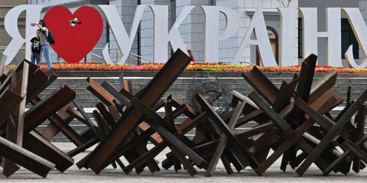 A woman takes a selfie with her son in front of letters forming "I love Ukraine" in the center of Kyiv on June 1, 2022 amid the Russian invasion of Ukraine. (Photo by Sergei SUPINSKY / AFP) (Photo by SERGEI SUPINSKY/AFP via Getty Images)